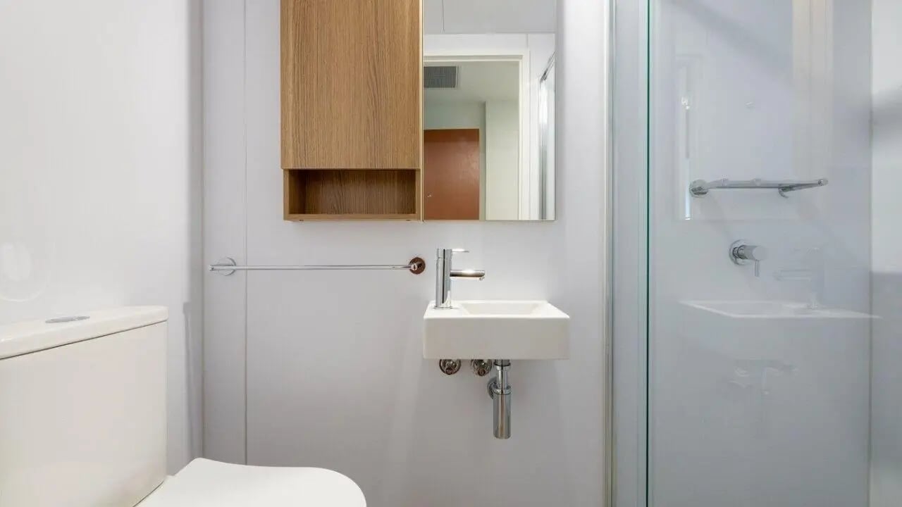 Toilet sink cabinet mirror and shower enclosure bathroom at UniLodge Brisbane City in Brisbane Student Accommodation