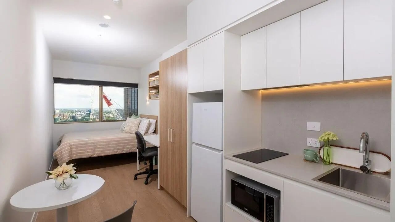 Bed desk kitchen and window view studio apartment at UniLodge Brisbane City in Brisbane Student Accommodation