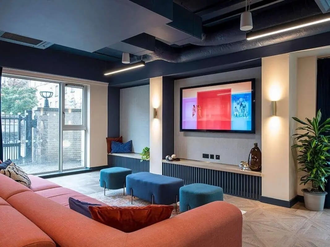 Pink couch blue ottomans large TV living room at Silk Mill Edinburgh in Edinburgh Student Accommodation