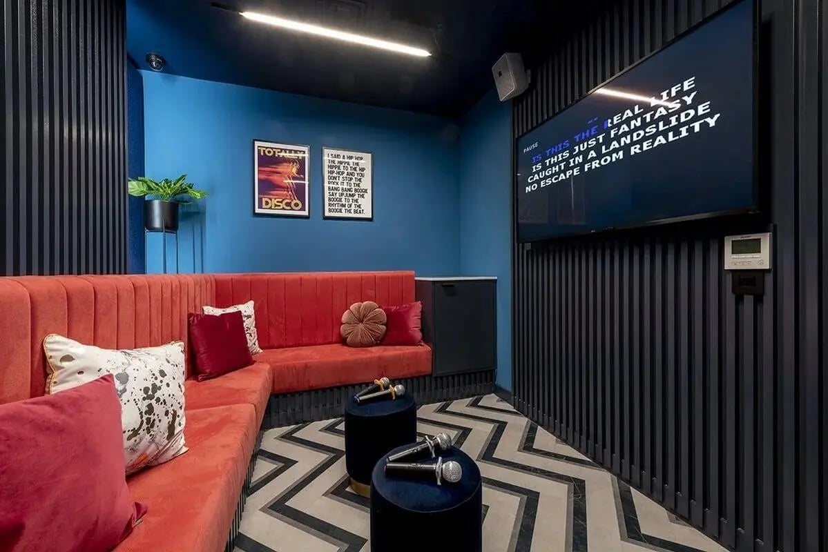 Red sofa microphones screen karaoke room at Silk Mill Edinburgh in Edinburgh Student Accommodation
