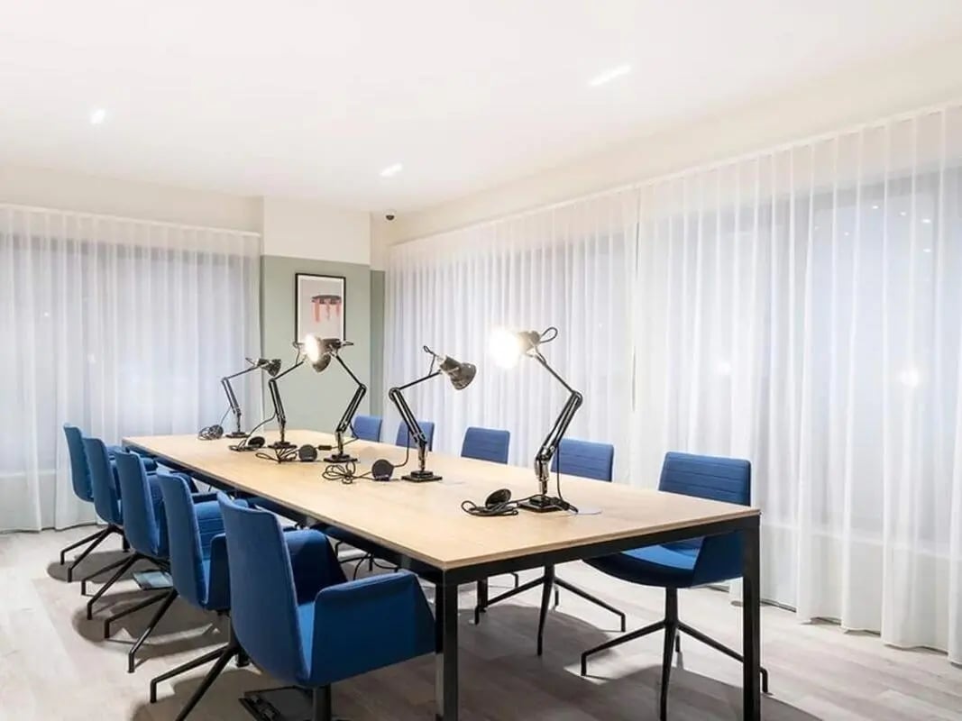 Table with desk lamps and blue chairs study area at Bridle Works Glasgow in Glasgow Student Accommodation