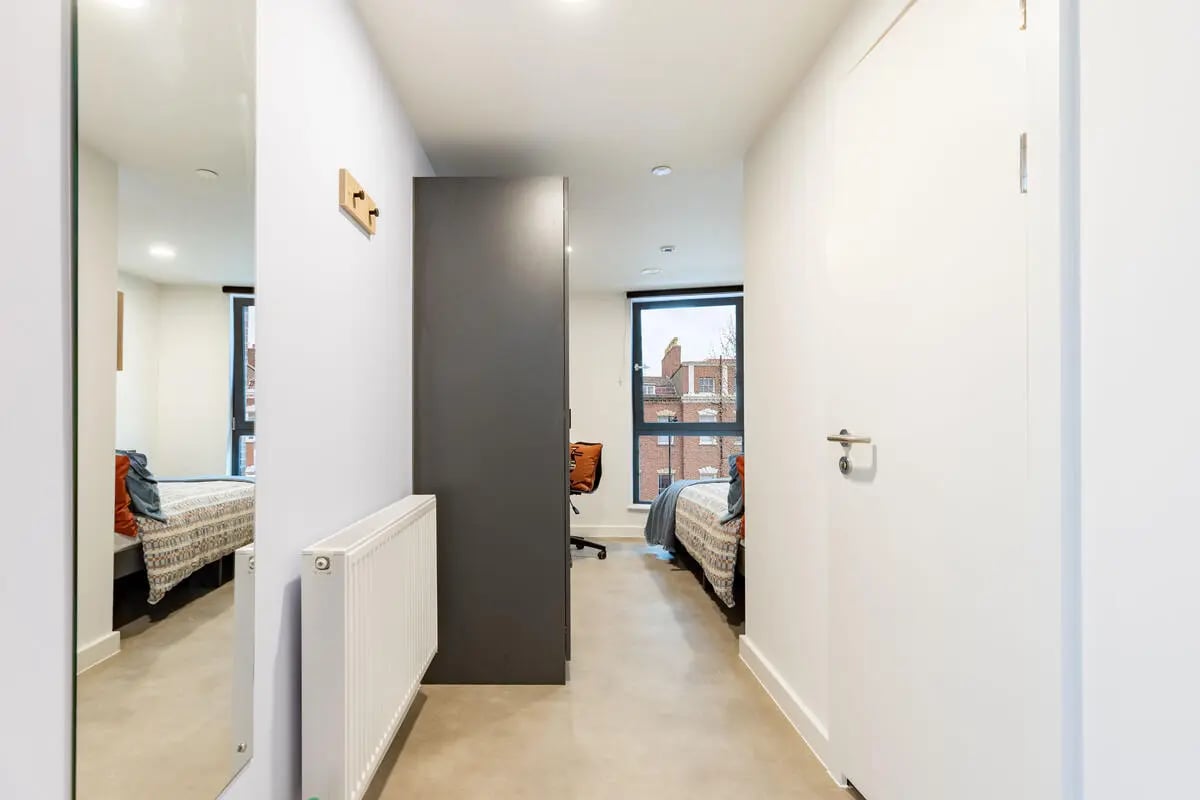 Hallway with mirror radiator wardrobe and bedroom at Croft Court in Bristol Student Accommodation