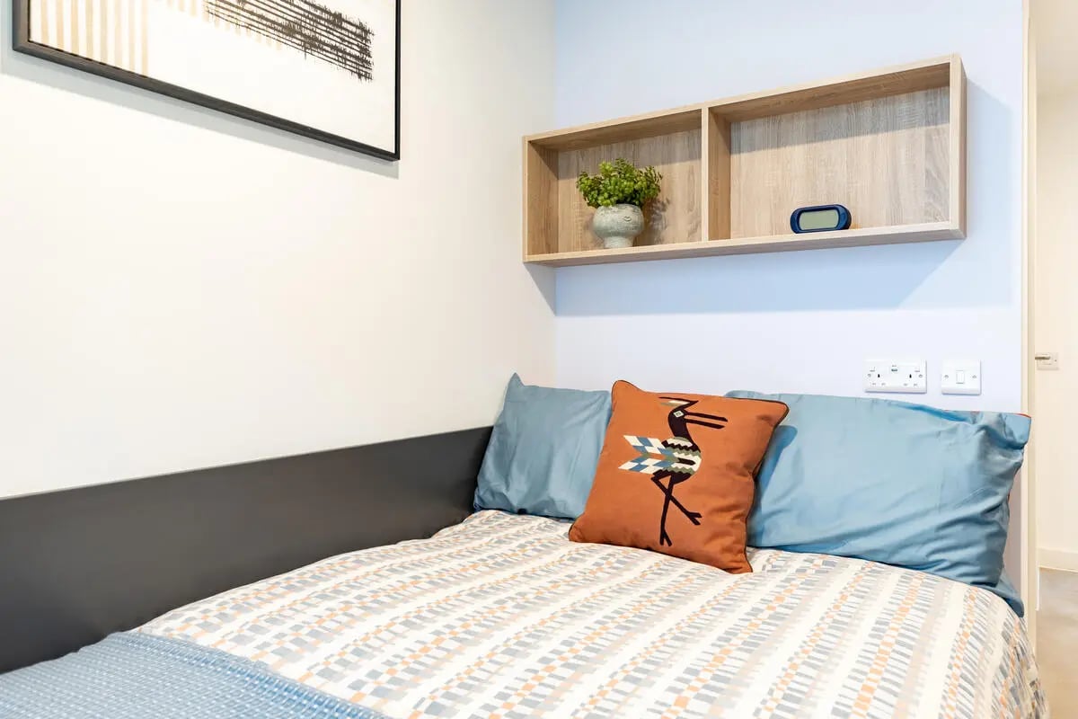 Bed with patterned duvet and bird pillow bedroom at Croft Court in Bristol Student Accommodation
