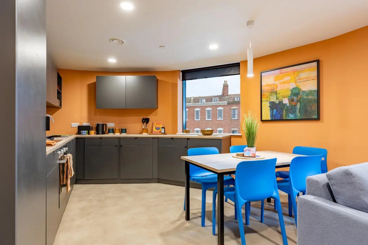 Modern kitchen with dining table and blue chairs kitchen at Croft Court in Bristol Student Accommodation