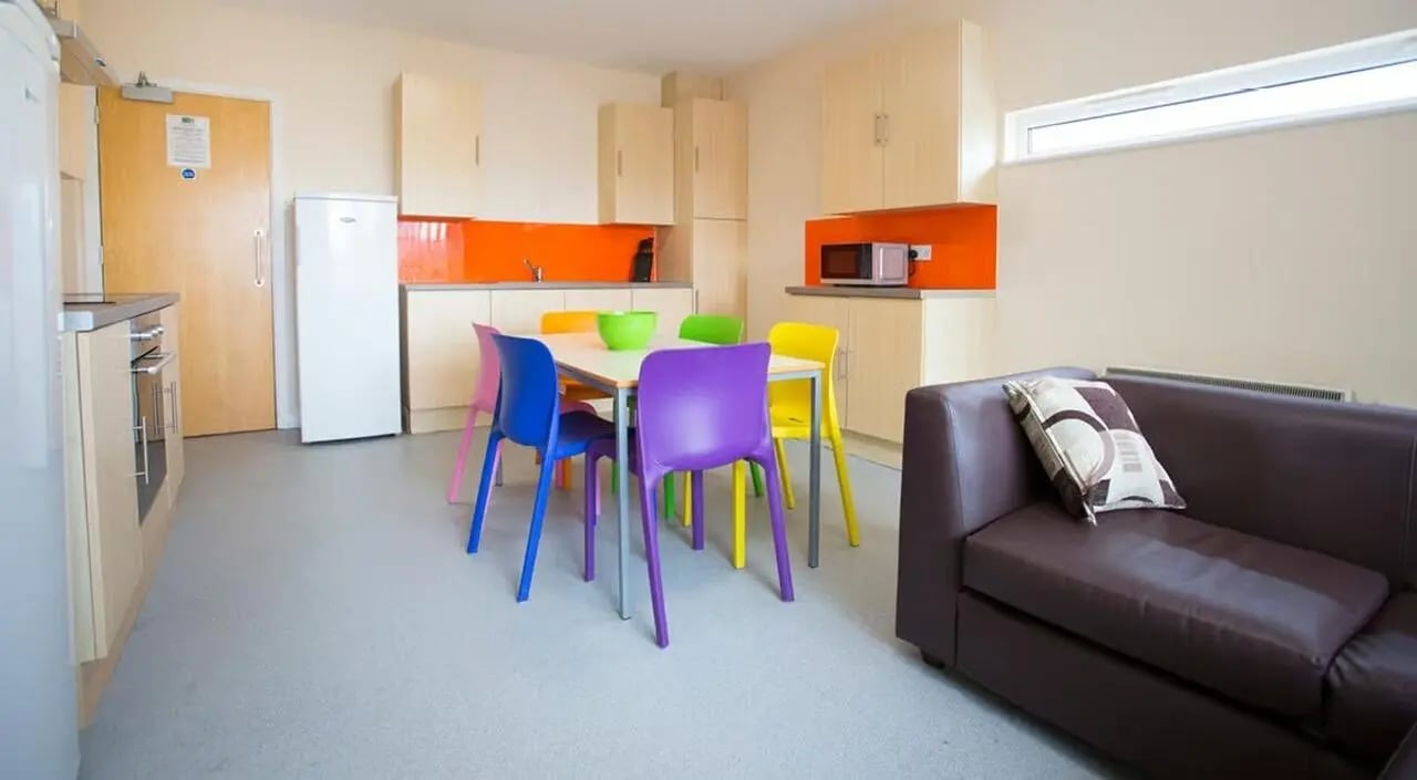 Table chairs fridge microwave couch living room at Brayford Quay in Lincoln Student Accommodation