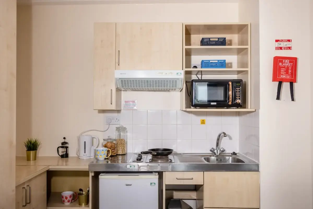 Microwave kettle storage sink and stove kitchen area. at Mcmillan student Village in Greenwich Student Accommodation