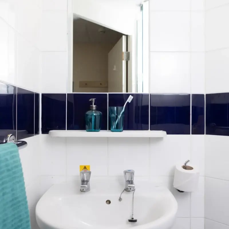 Sink soap dispenser toothbrush and toilet roll bathroom at Mcmillan student Village in Greenwich Student Accommodation