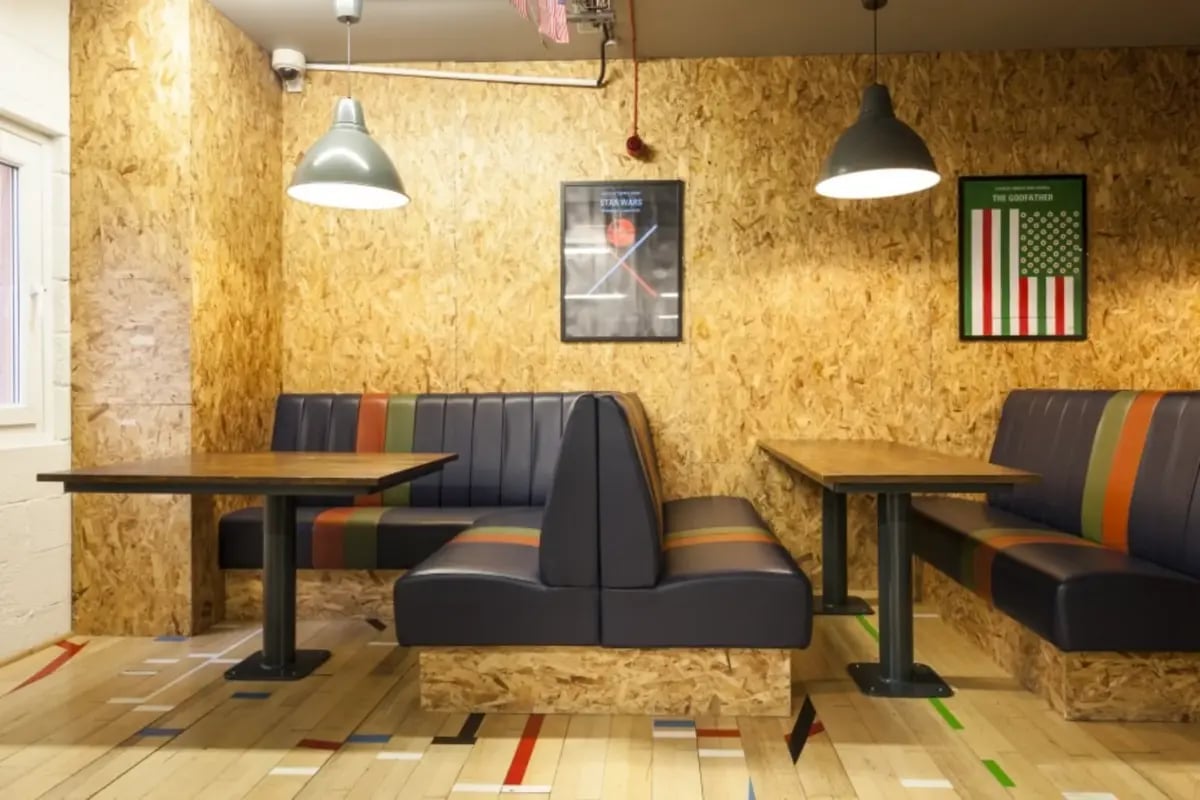 Booth seating tables pendant lights posters lounge at Mcmillan student Village in Greenwich Student Accommodation