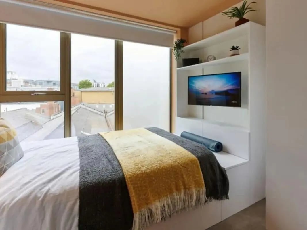 Bed with blankets TV on shelf bedroom at View Studios in London Student Accommodation