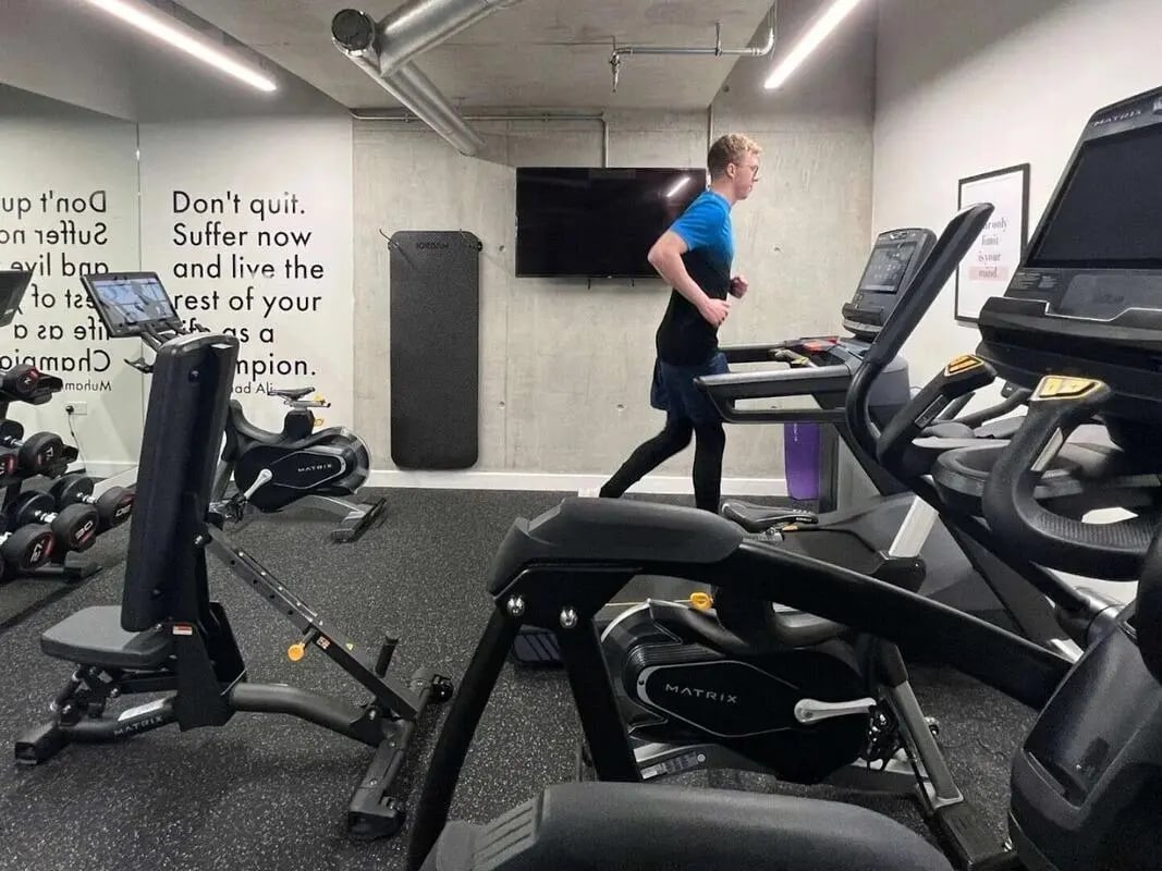Man running treadmill weight rack gym equipment gym at View Studios in London Student Accommodation