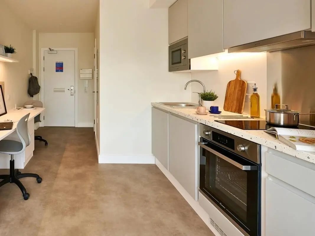 Desk chairs oven sink cabinets kitchen studio at View Studios in London Student Accommodation