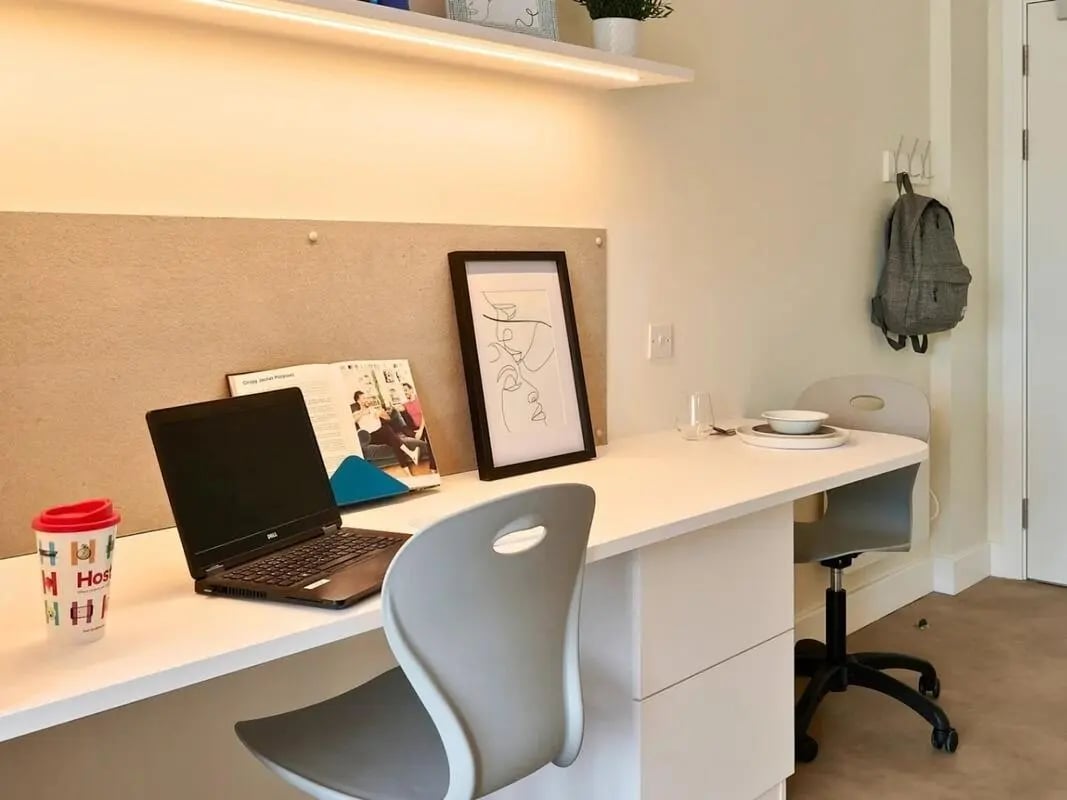 Laptop cup book framed art backpack study area at View Studios in London Student Accommodation