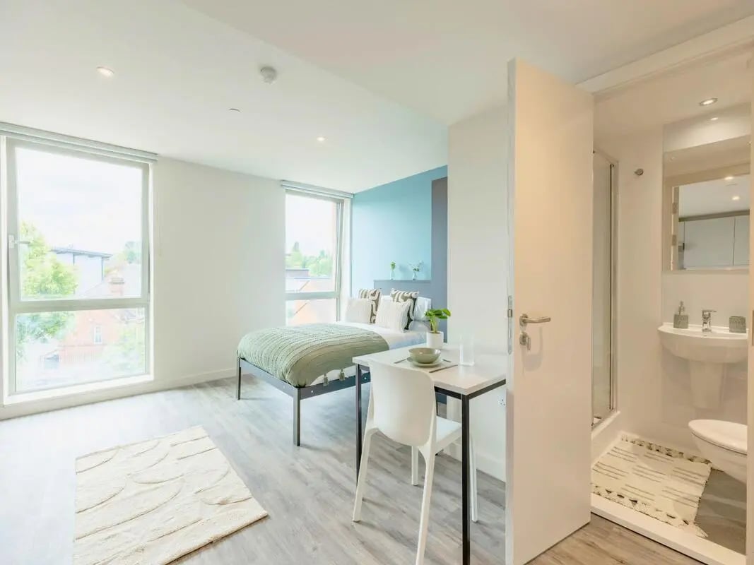 Bed table chair rug and bathroom Bedroom at Pershore Junction in Birmingham Student Accommodation