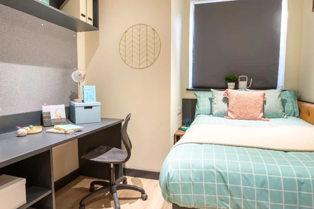 Desk chair lamp bed and pillows bedroom at Crown House Brighton in Brighton Student Accommodation
