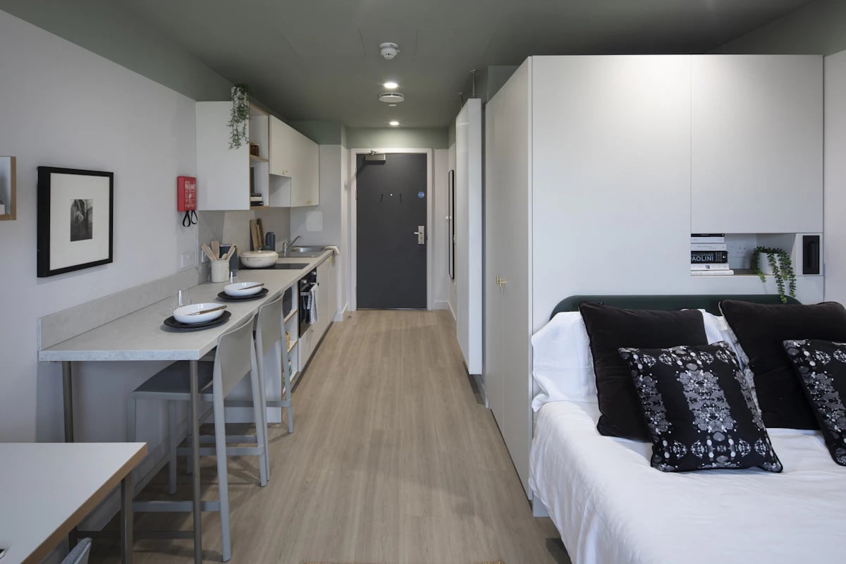 Kitchenette counter with bar stools and bed. Studio room. at The Keel Houses in Edinburgh Student Accommodation