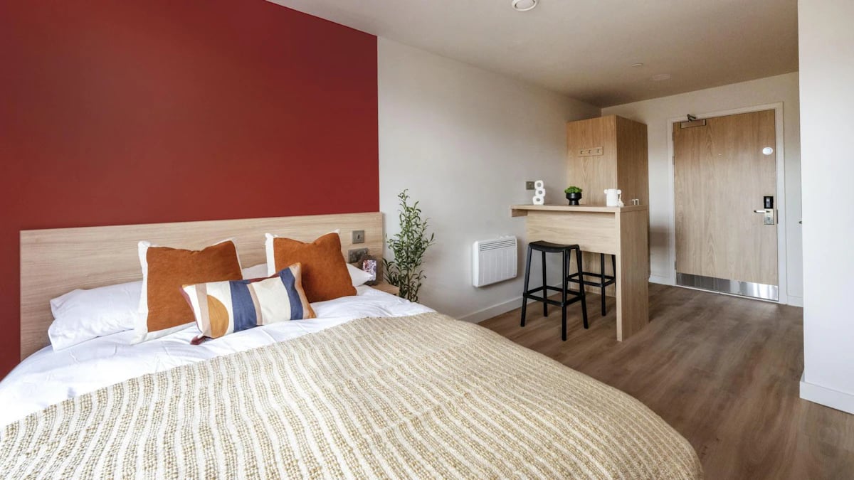 Bed with pillows breakfast bar two stools bedroom at Haymarket Yards in Edinburgh Student Accommodation