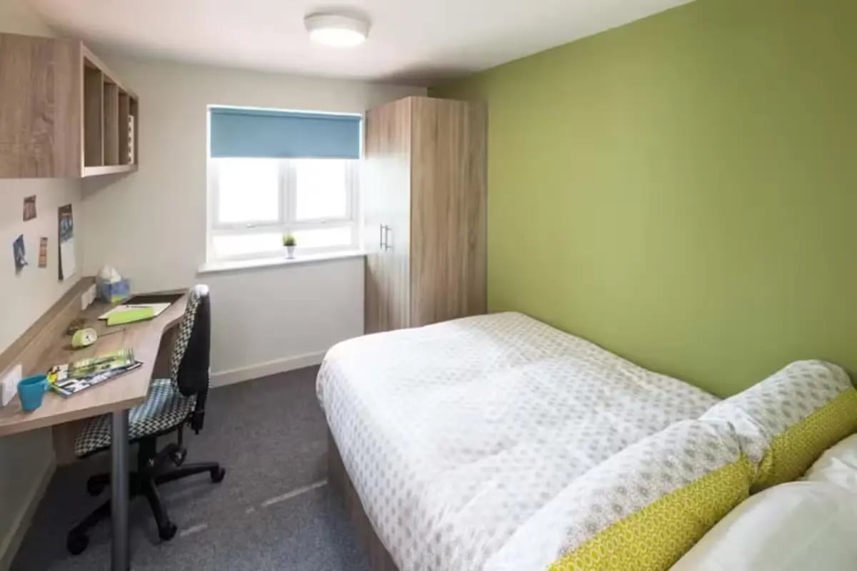 Bed desk wardrobe with white bedding bedroom at Selly Oak Court in Birmingham Student Accommodation