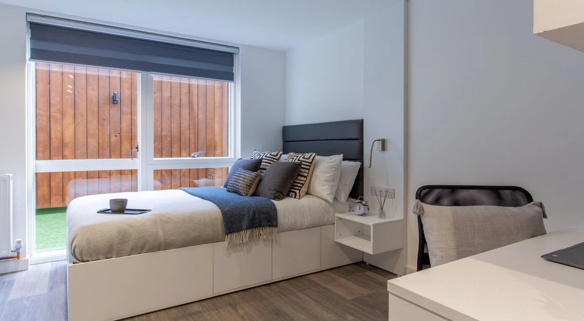 Bed with pillows bedside table and chair bedroom at Miura in Nottingham Student Accommodation
