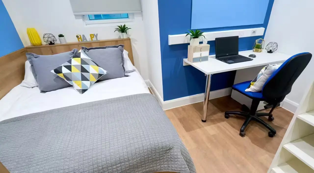 Bed laptop desk chair and shelving unit bedroom at St Leonard's House in Lancaster Student Accommodation