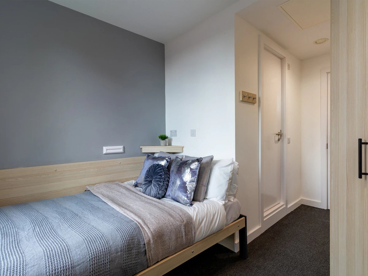 Bed with pillows and blankets bedroom at Straits Village in Nottingham Student Accommodation