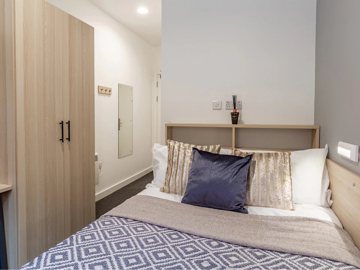 Wardrobe mirror bed with pillows and diffuser Bedroom at Straits Village in Nottingham Student Accommodation