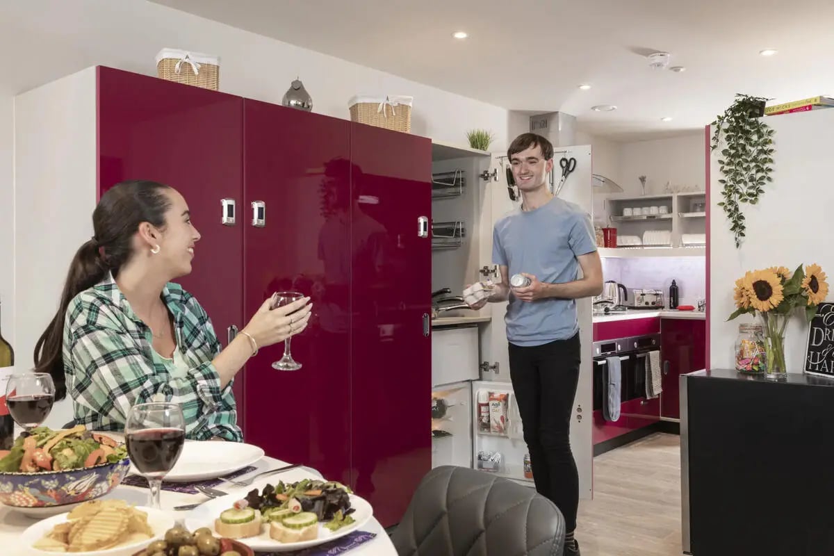 Two people in a kitchen with food kitchen at Brotherton House in Leeds Student Accommodation