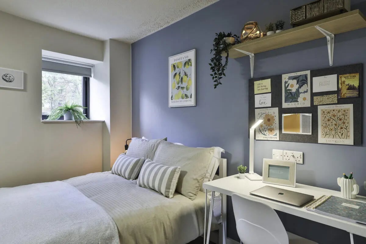 Bed desk framed pictures plants bedroom at Ladybarn House in Manchester Student Accommodation