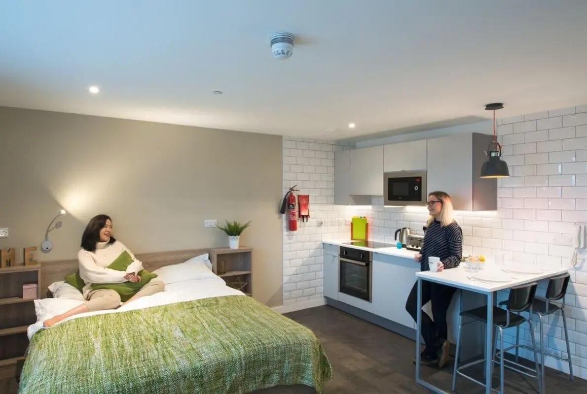 Bed kitchen area with people and furniture living room at CityBlock Marton Street in Lancaster Student Accommodation