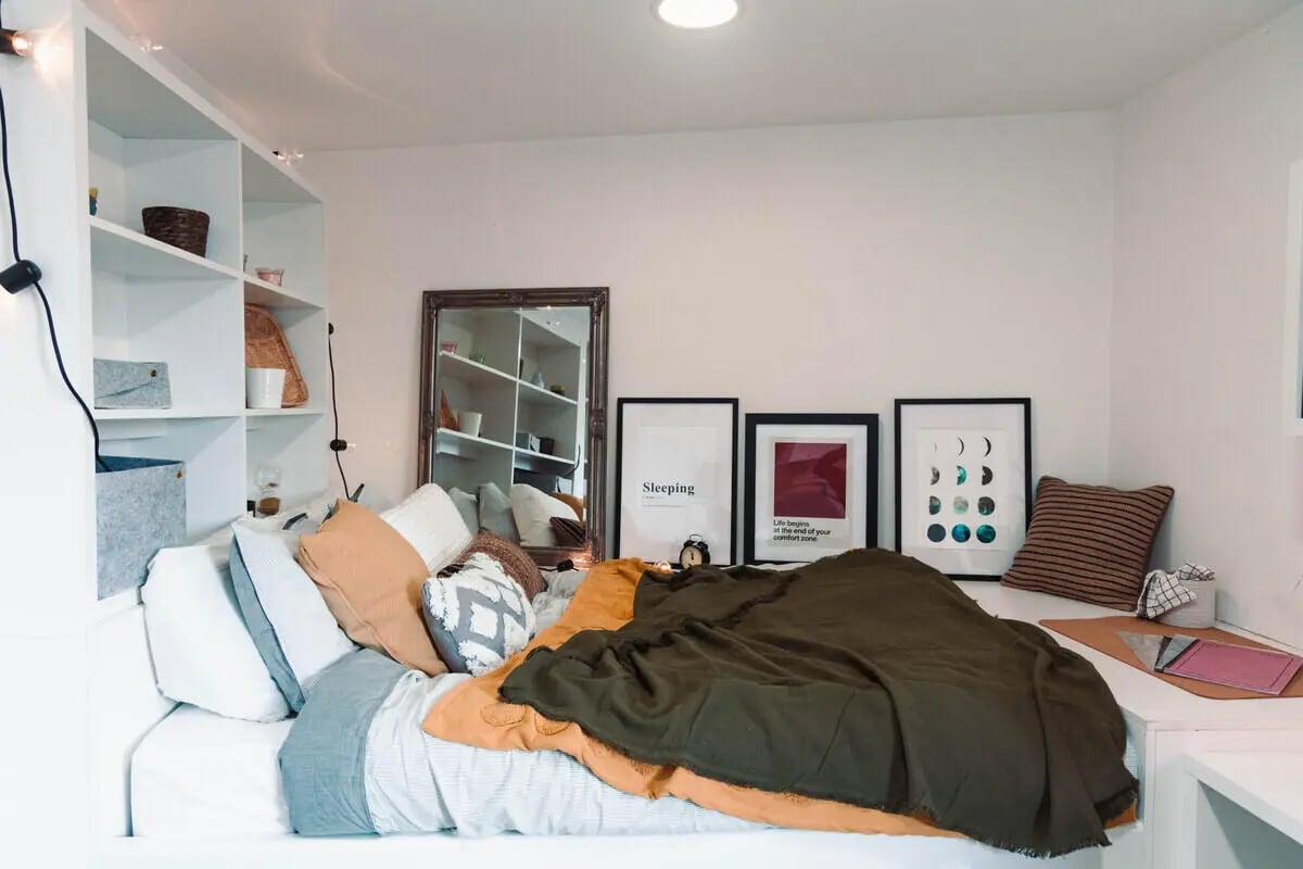 Bed with pillows shelves mirror and art Bedroom at Stonebridge House in Bristol Student Accommodation