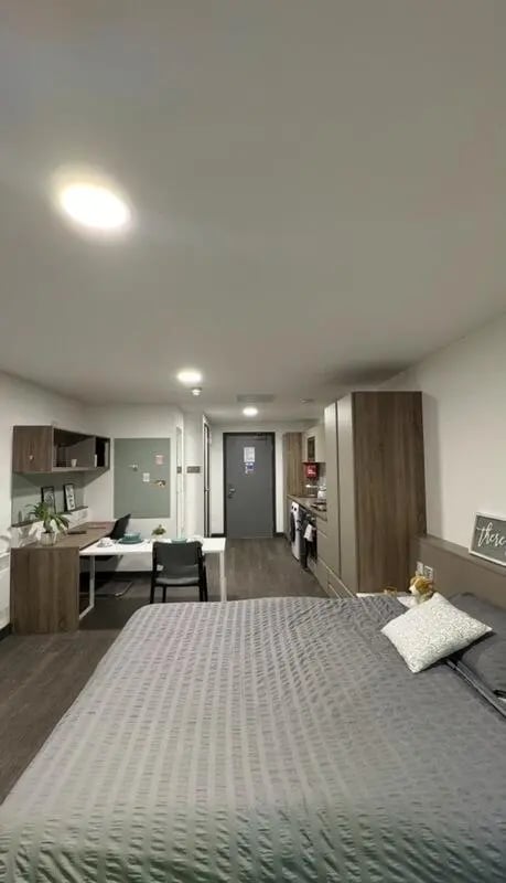 Bed desk kitchen area and door studio apartment at Sycamore House in Leeds Student Accommodation
