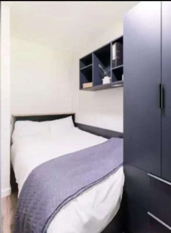Bed with purple blanket and dark blue wardrobe bedroom at Lyon Street Terrace in Dundee Student Accommodation