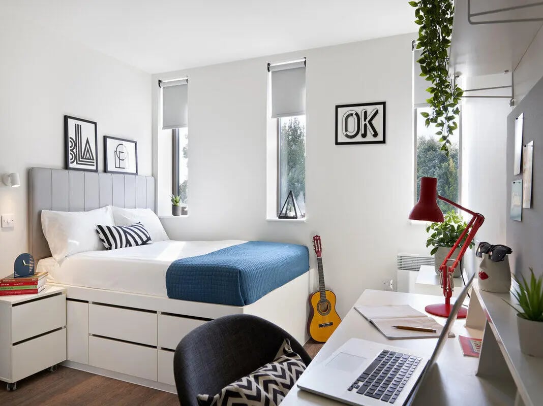 Bed desk guitar laptop and chair bedroom at Student Castle Oxford in Oxford Student Accommodation