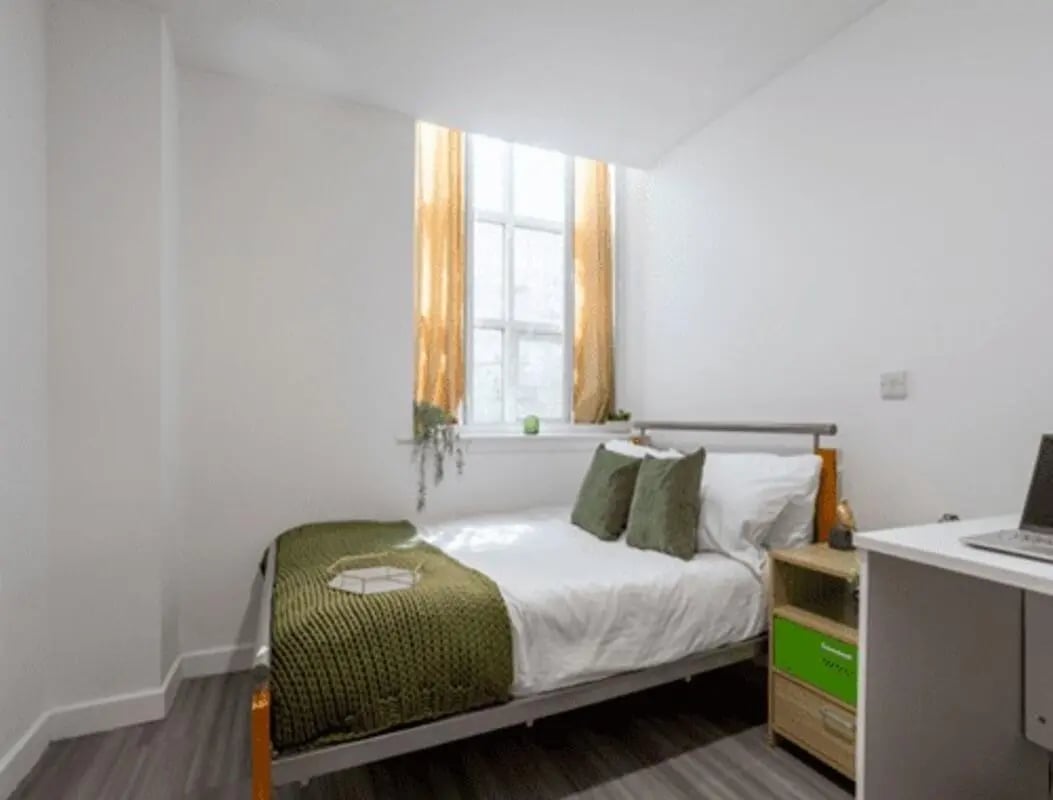 Bed with green throw and desk Bedroom at dwell Castle Gate Haus in Nottingham Student Accommodation