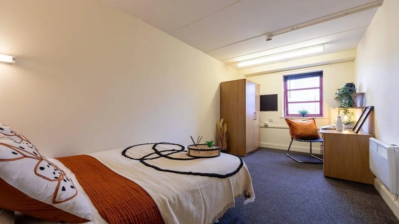 Bed wardrobe desk chair and radiator bedroom at Manchester Student Village in Manchester Student Accommodation
