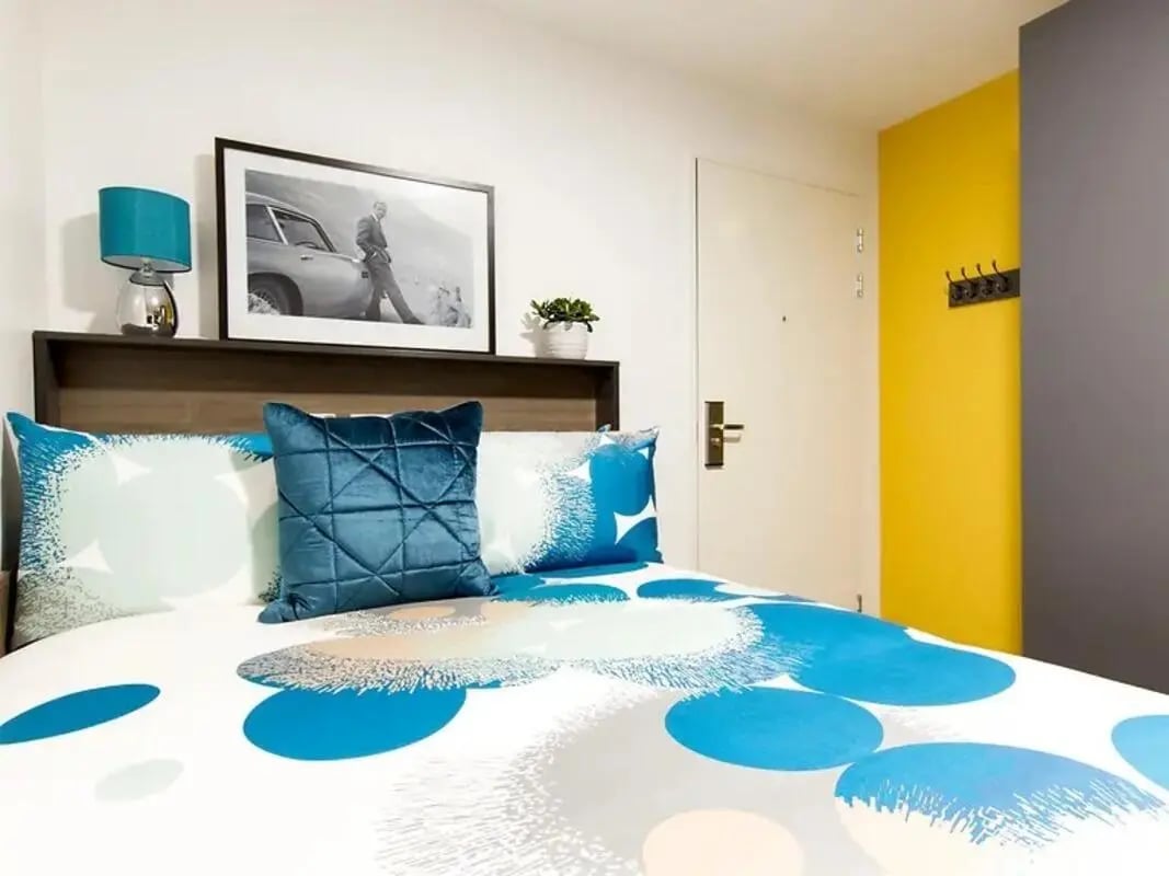 Bed with blue patterned duvet and pillows bedroom at Yugo Beckley Point in Plymouth Student Accommodation