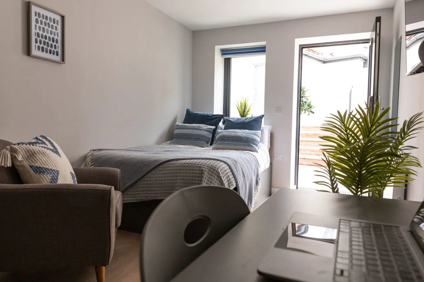 Bed armchair and desk with laptop Bedroom at Boutique Student Living - Exeter in Exeter Student Accommodation