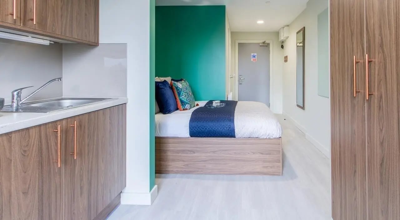 Kitchen counter bed with pillows closet and door bedroom at The Toybox in Birmingham Student Accommodation