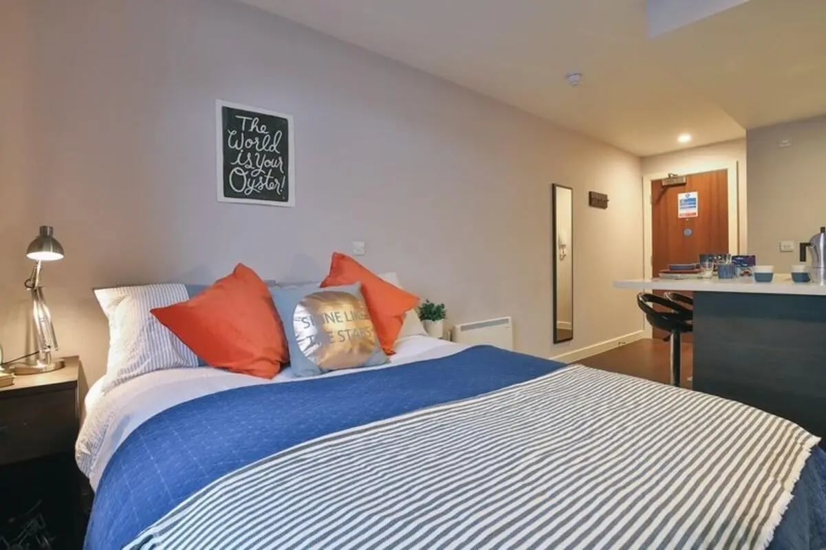 Bed with pillows lamp framed art and bar area Bedroom at Talbot Studios in Nottingham Student Accommodation