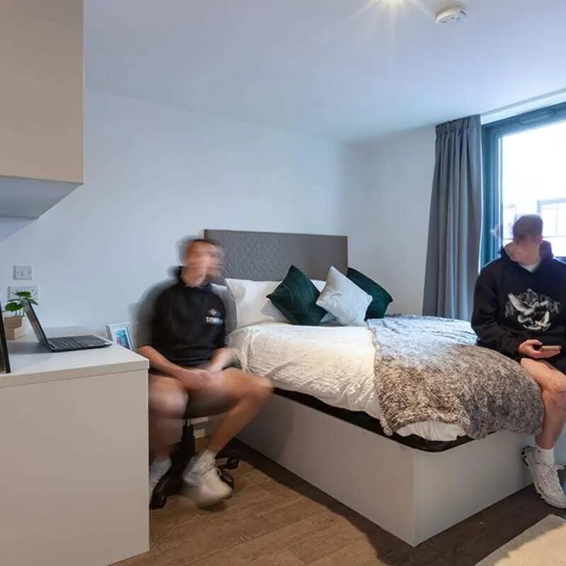 Two men and a bed in a bedroom at True Liverpool in Liverpool Student Accommodation