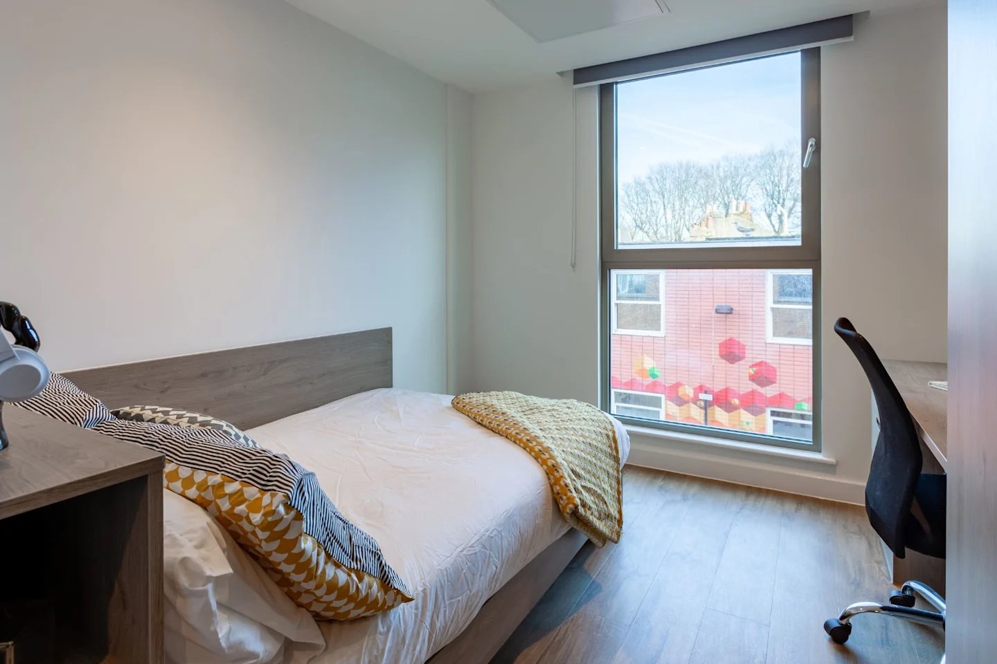 Bed desk and chair near window bedroom at Pavilion Point in Brighton Student Accommodation