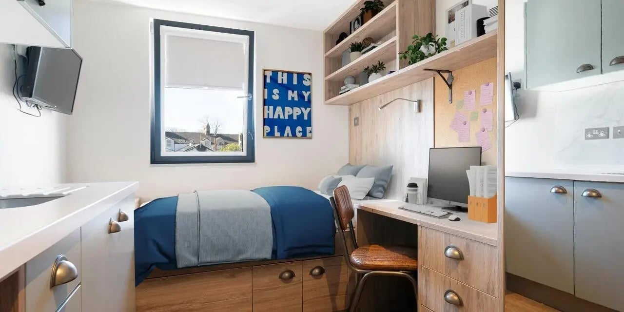 Bed desk shelves and kitchen area bedroom at Canvas The Parade in Cardiff Student Accommodation
