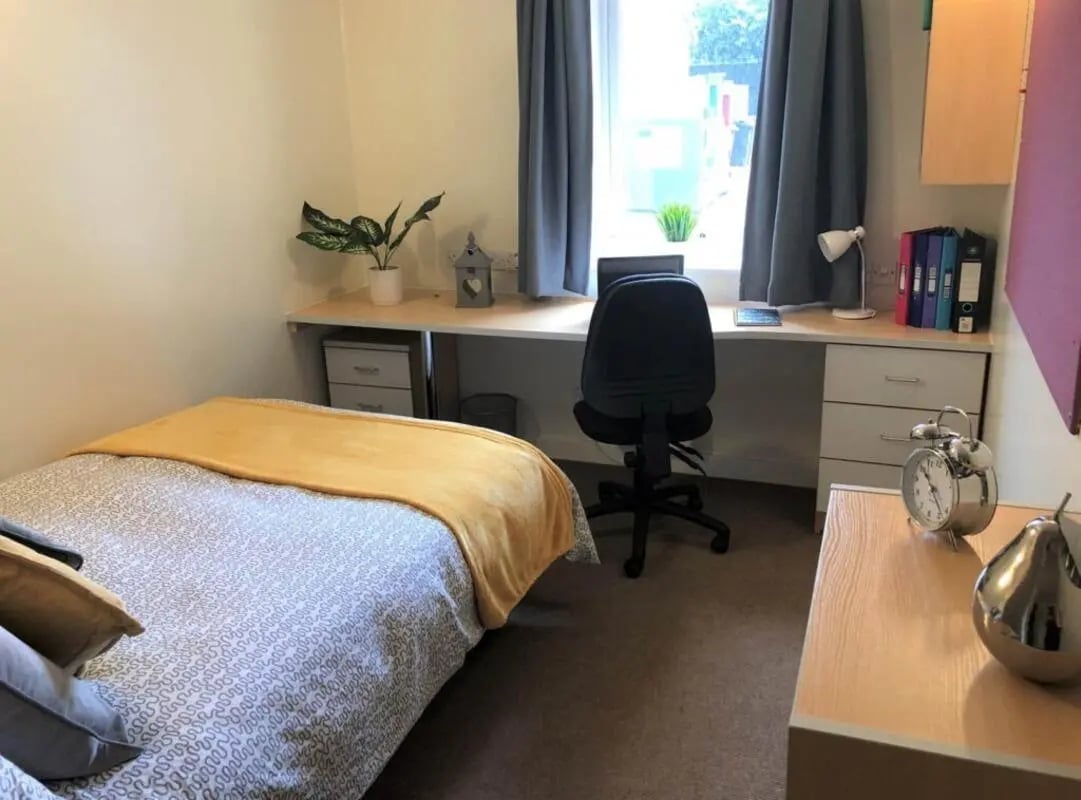 Bed desk chair and alarm clock bedroom at Horton House Bradford in Bradford Student Accommodation