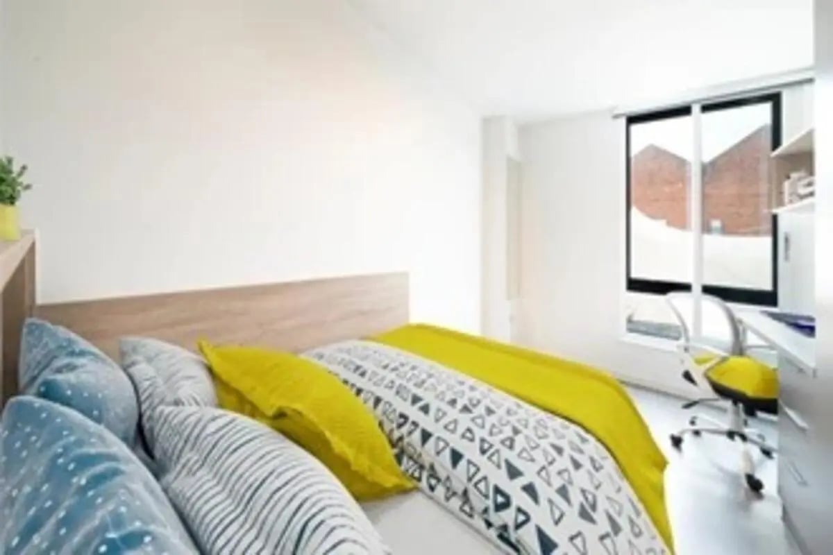 Bed pillows desk chair and window bedroom at Canvas Bristol in Bristol Student Accommodation