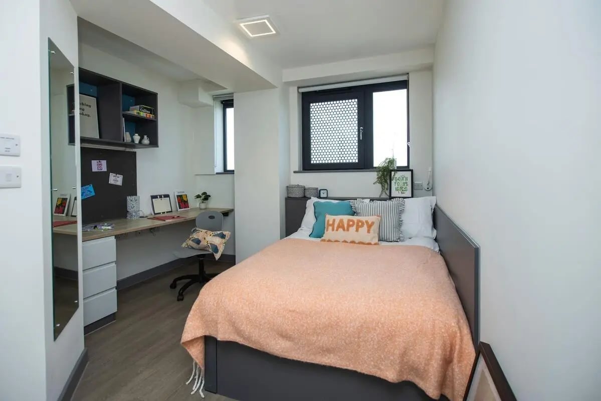 Bed desk shelves pillows and mirror bedroom at Canvas Capital House in Southampton Student Accommodation