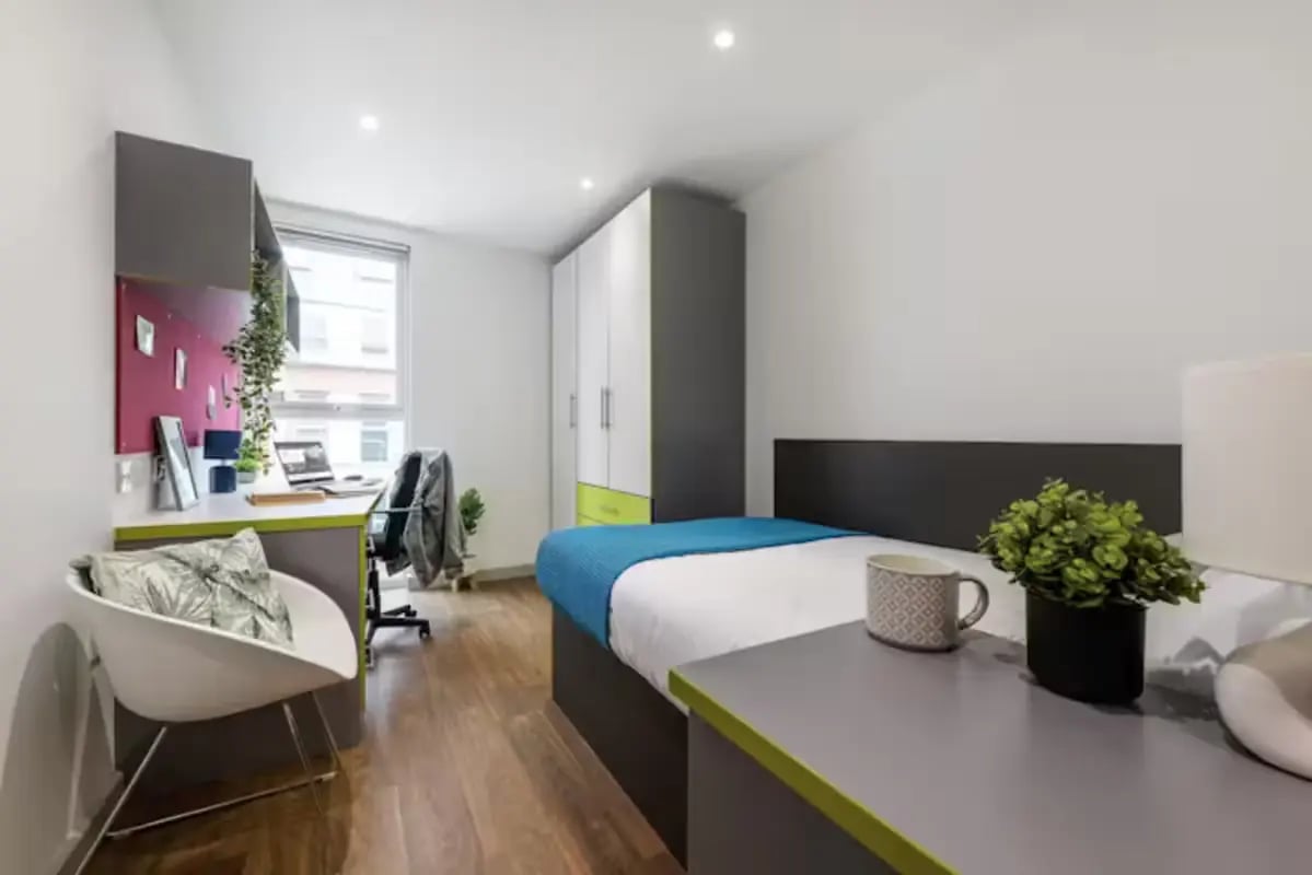 Bed desk chair wardrobe with blue blanket bedroom at The Boulevard in York Student Accommodation