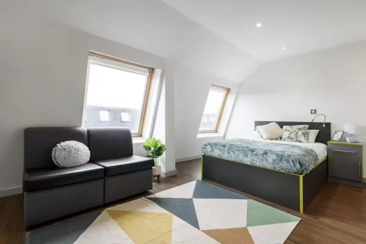 Sofa bed nightstand plant geometric rug bedroom at The Boulevard in York Student Accommodation