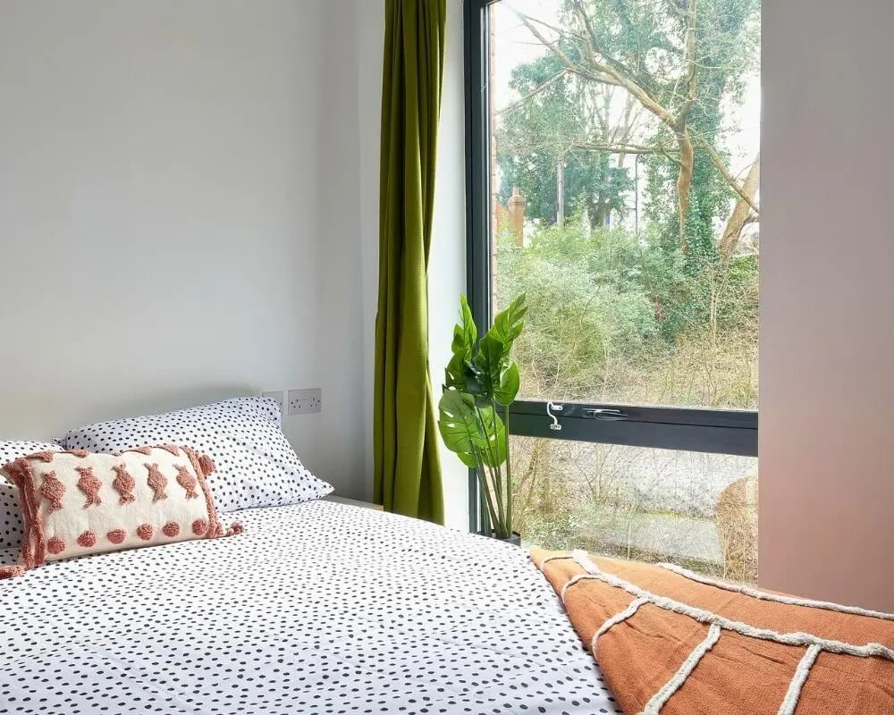 Bed with patterned duvet and cushion bedroom at The Village at The Viaduct in Durham Student Accommodation