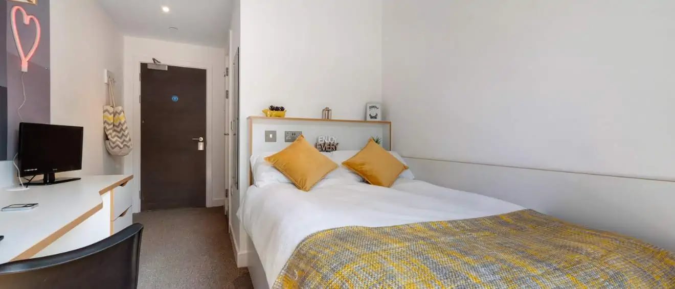 Bed desk and door in student bedroom at 27 Magdalen Street in Colchester Student Accommodation