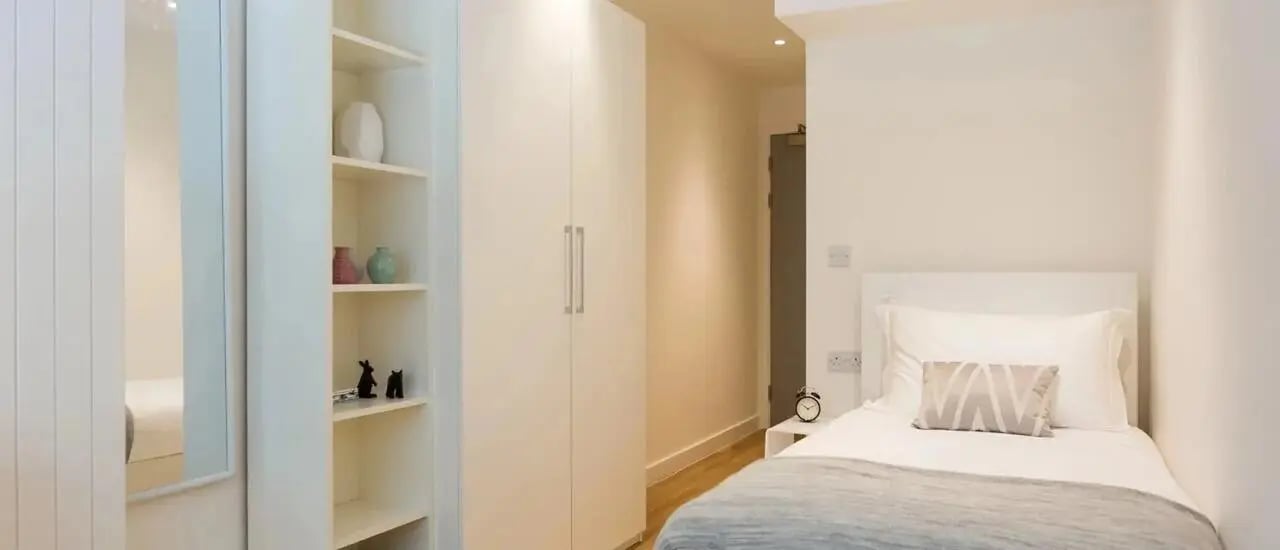 Single bed shelves and closet bedroom at Chapter Aldgate in London Student Accommodation