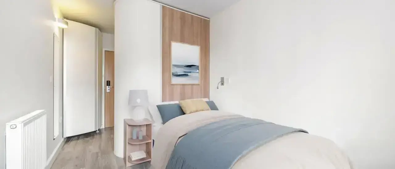 Bed lamp and painting in a bedroom at Chapter Highbury in London Student Accommodation